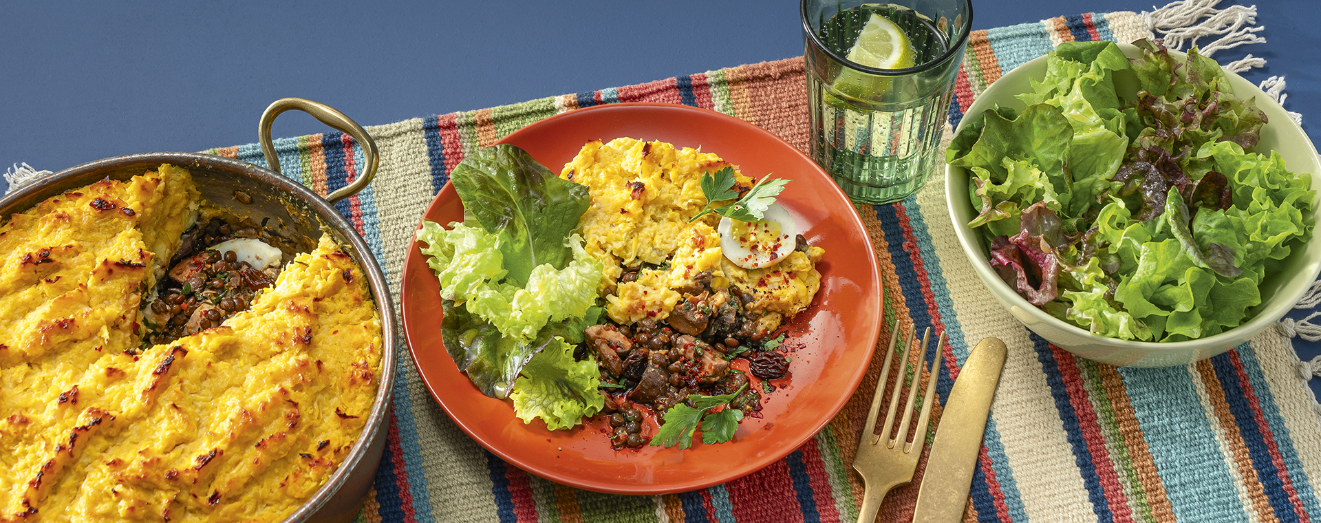 Maisauflauf mit Linsen-Pilz-Füllung und grünem Salat, angerichtet auf einem Teller.