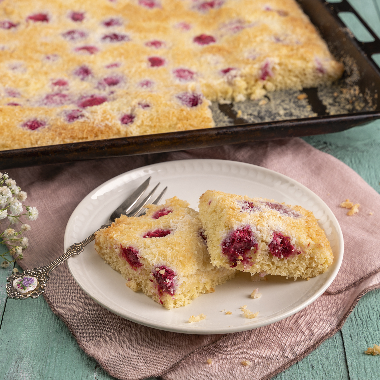 Saftiger Kokoskuchen vom Blech mit versunkenen Himbeeren.
